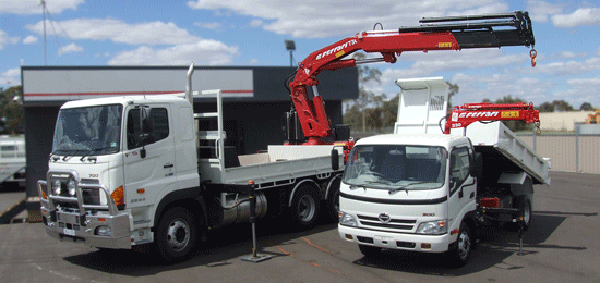 Two white trucks with crane attachments