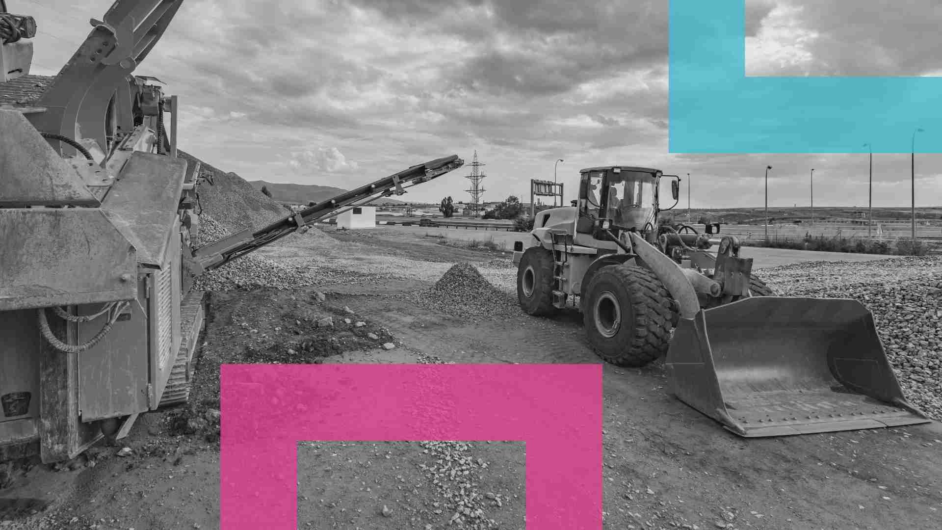 A digger parked on a worksite surrounded by rocks and gravel