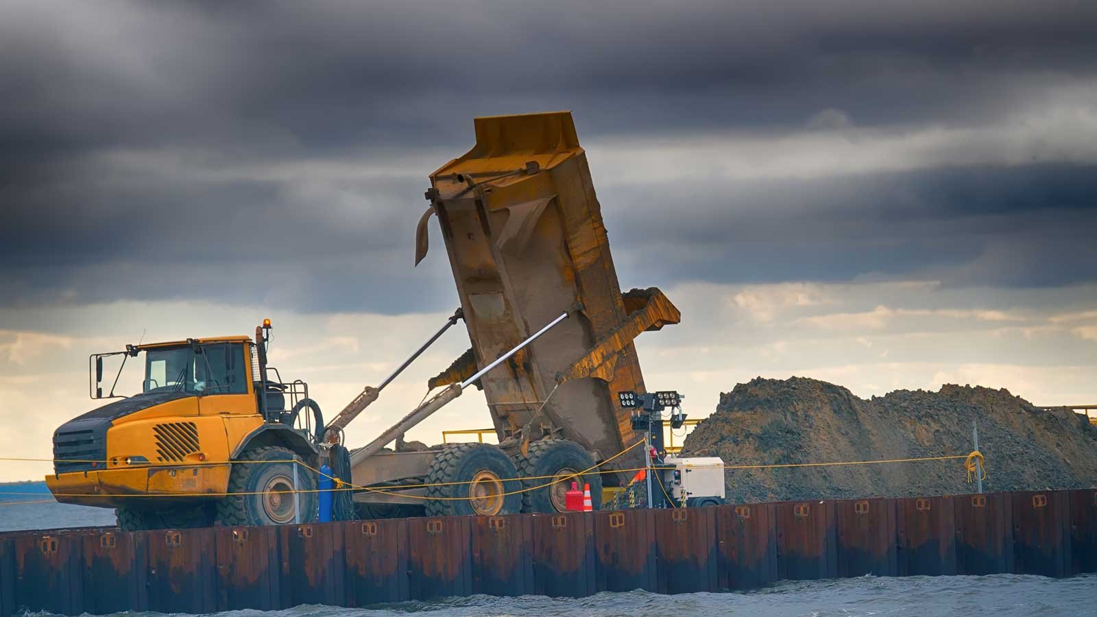 Tip truck unloading a dirt pile on a construction site