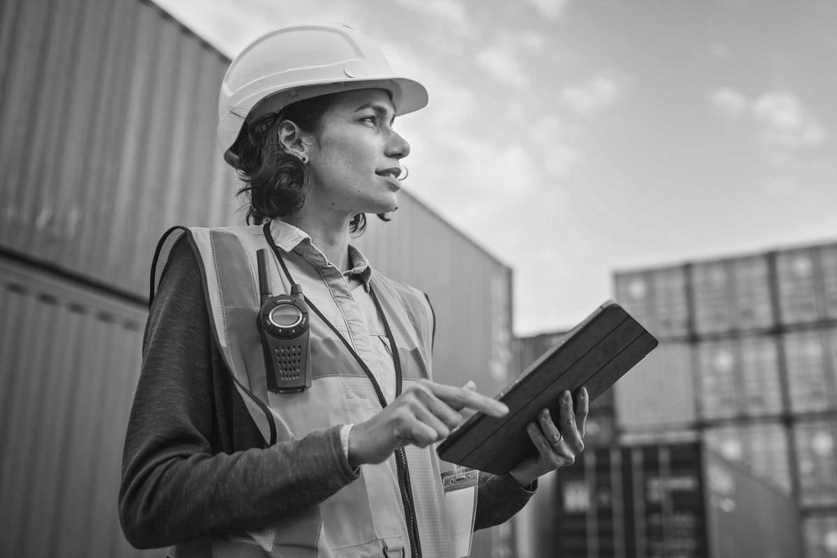 Female safety manager overseeing construction site with ipad