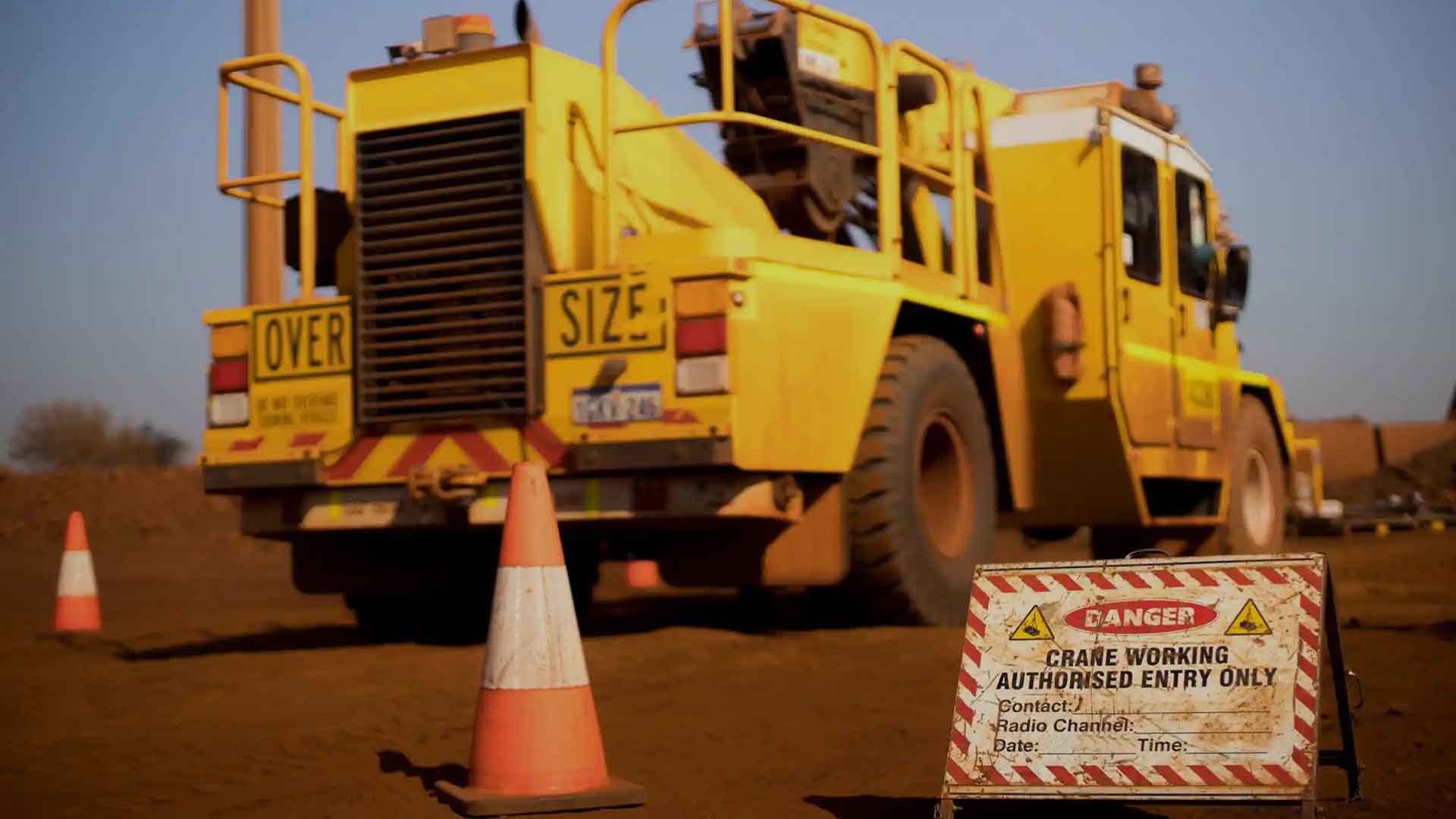 heavy yellow machinery with danger sign in the foreground