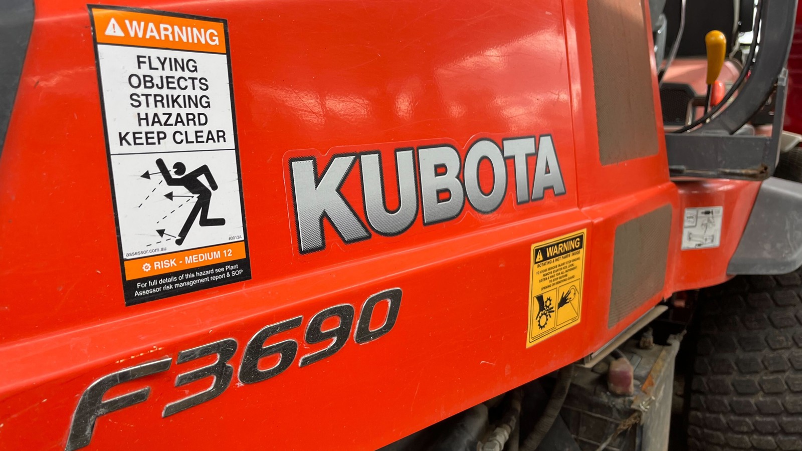 flying objects safety label on a red kubota machine