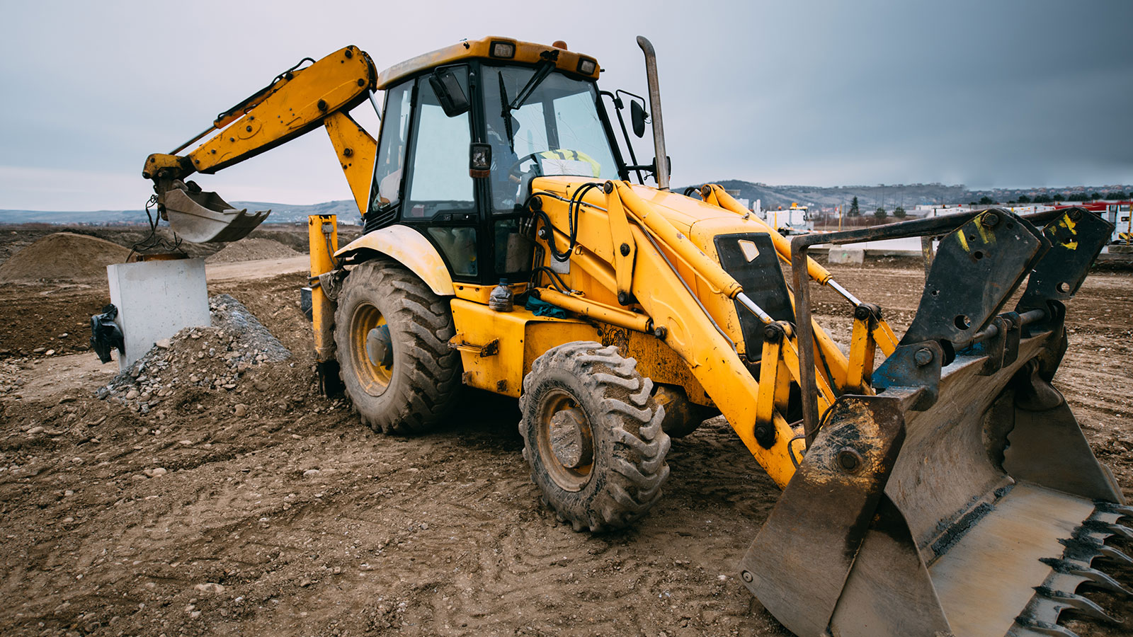 yellow front end loader on a dirt work site