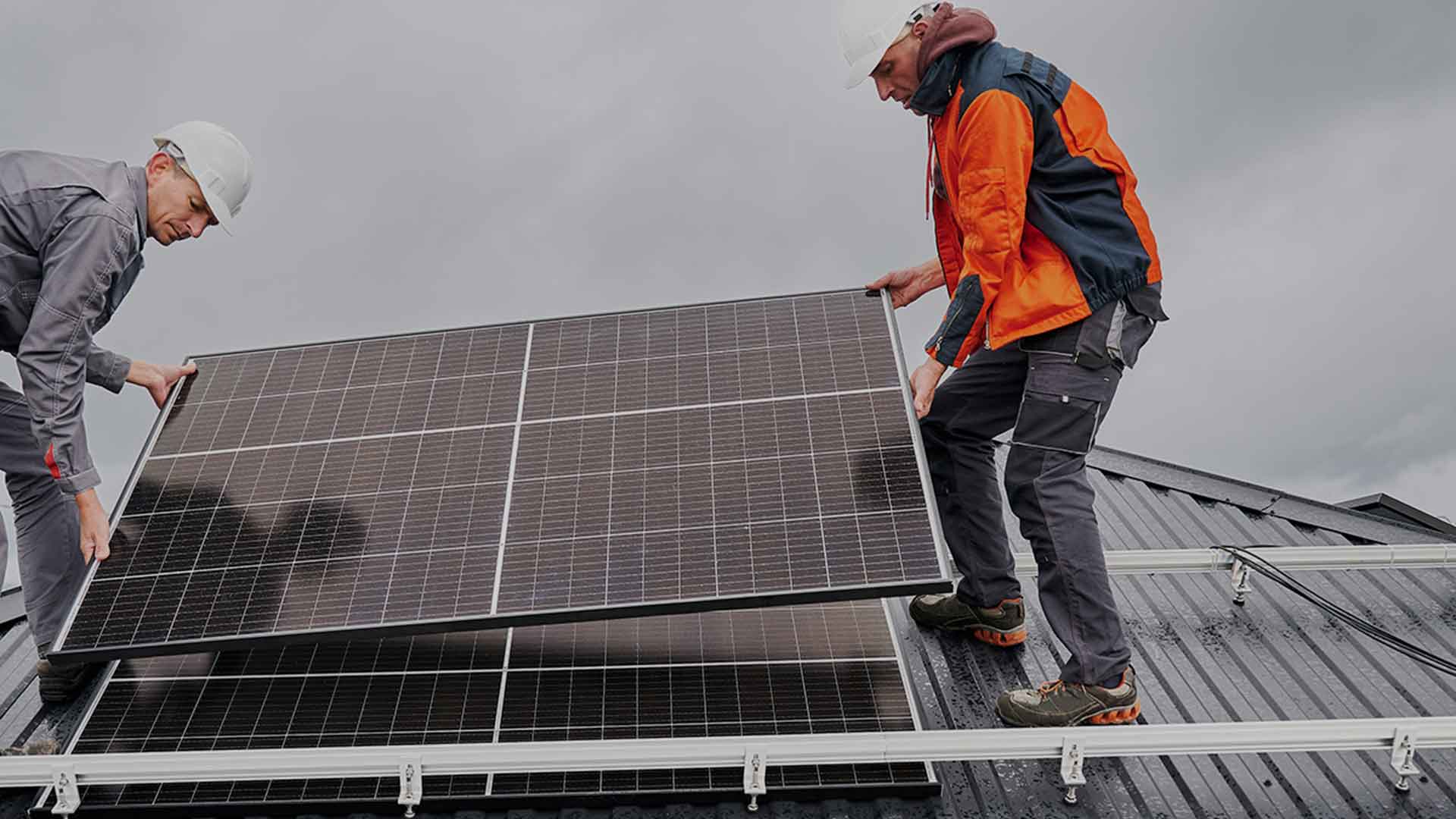 man installing a solar panel on a roof