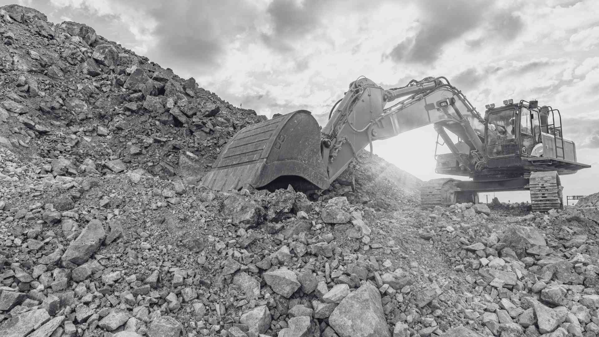 Excavator scooping rubble on a work site