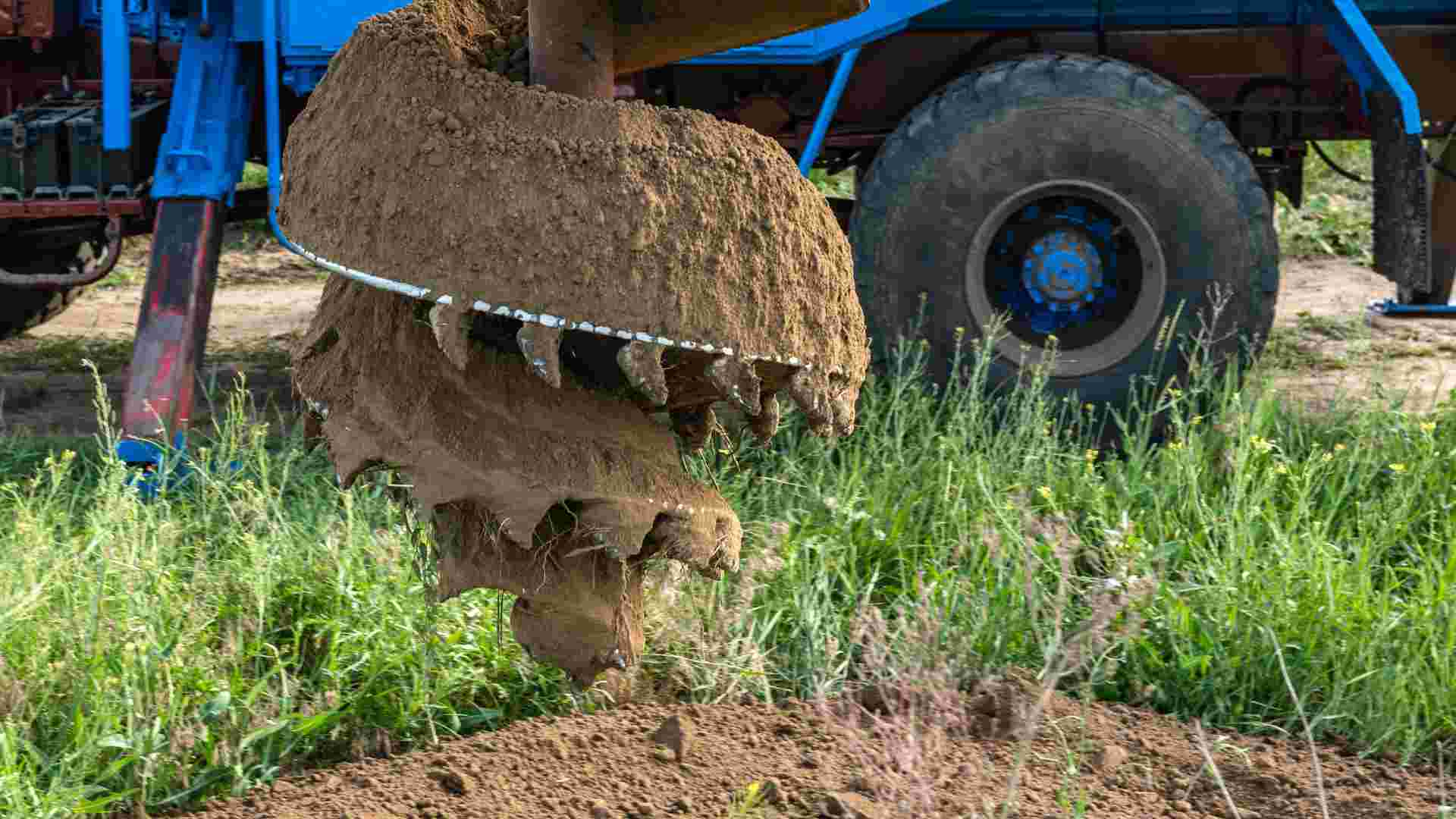 Close up of an unguarded auger on a blue machine