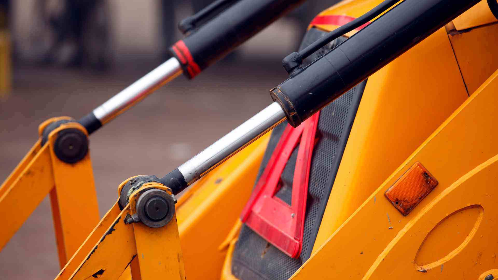 Close up of a yellow heavy machine with red warning label