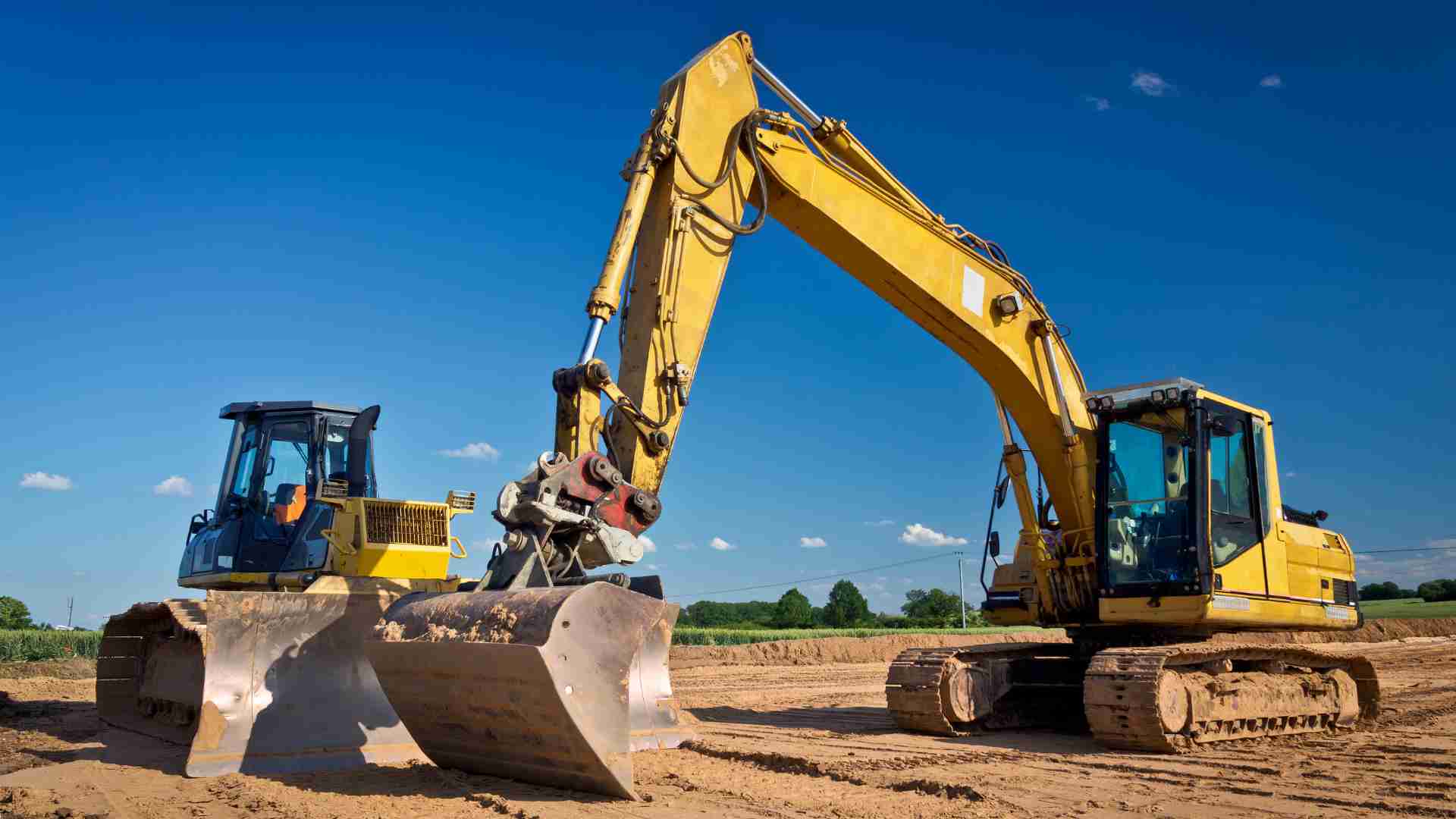Two yellow heavy machines on a construction site