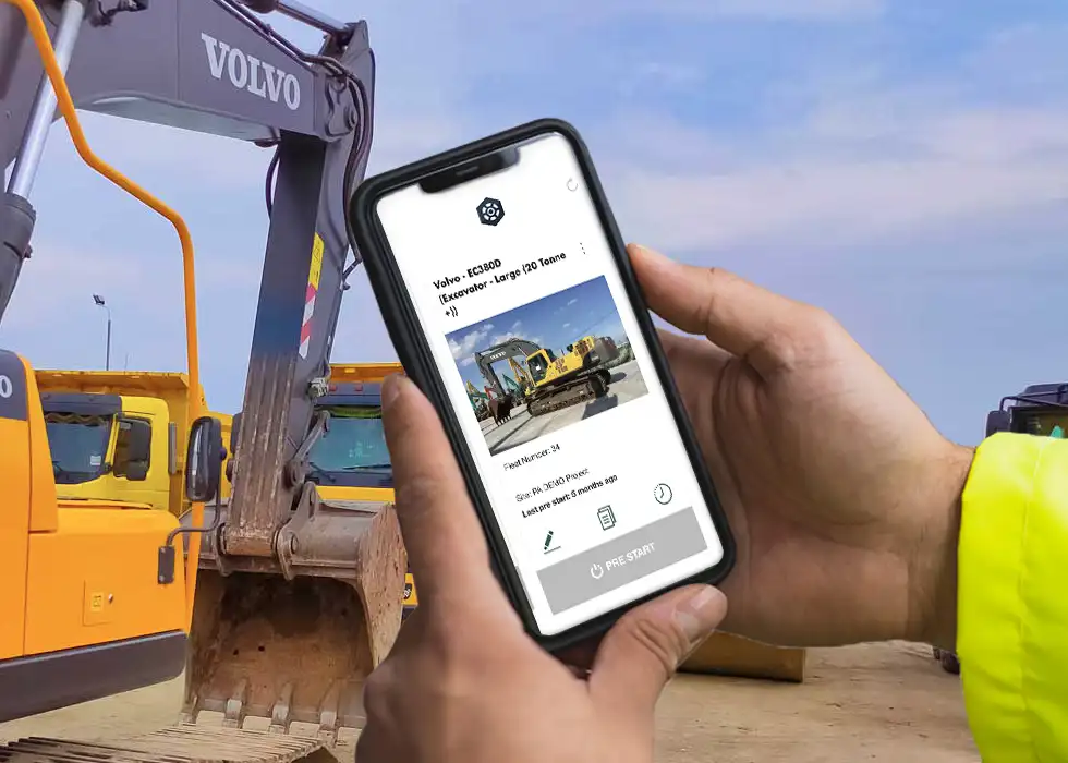 Man holding phone showing a pre start being conducted on yellow volvo excavator in background