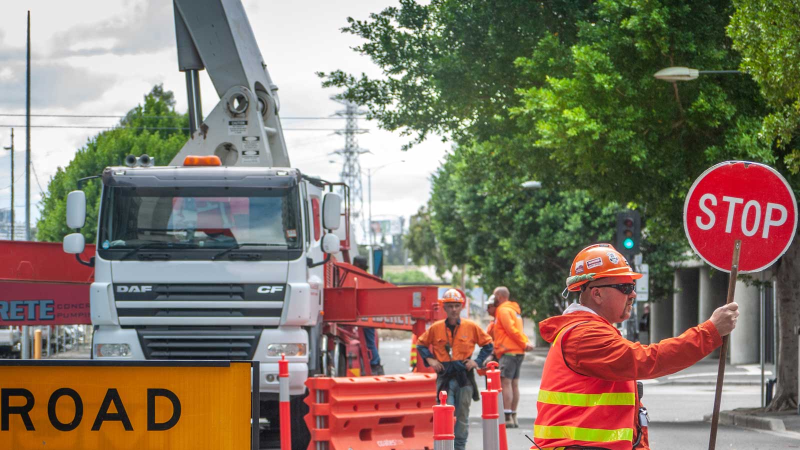 Machinery and workers in high vis conducting road work for local government